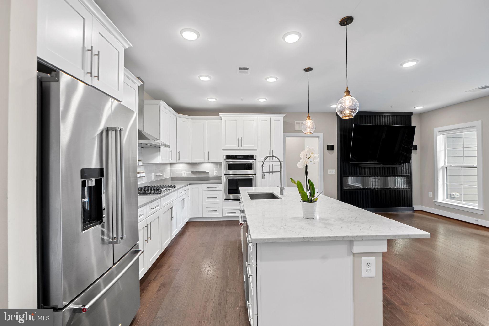 210 Decoverly Drive, Unit 106 Gaithersburg, MD 20878 - Photo 13 of 59 a kitchen with refrigerator a microwave and wooden floor