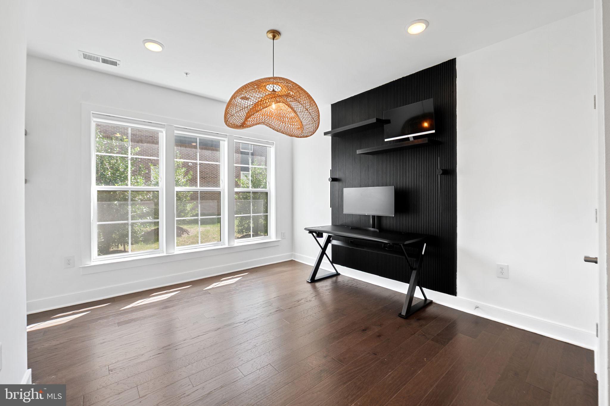 210 Decoverly Drive, Unit 106 Gaithersburg, MD 20878 - Photo 29 of 59 an empty room with wooden floor and windows