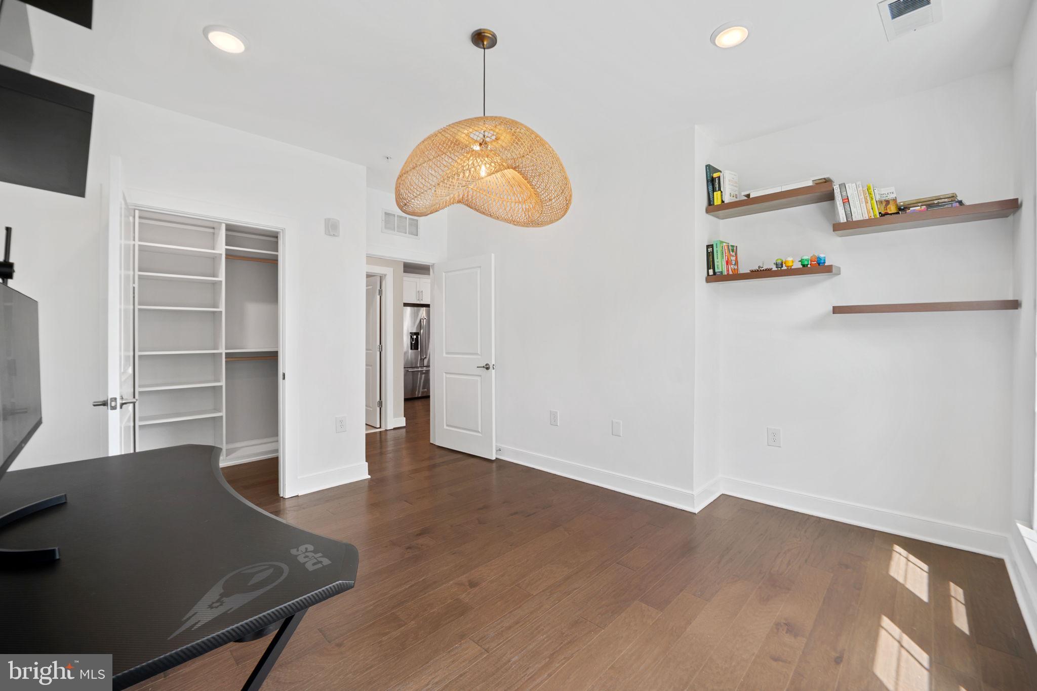 210 Decoverly Drive, Unit 106 Gaithersburg, MD 20878 - Photo 30 of 59 an empty room with wooden floor and windows