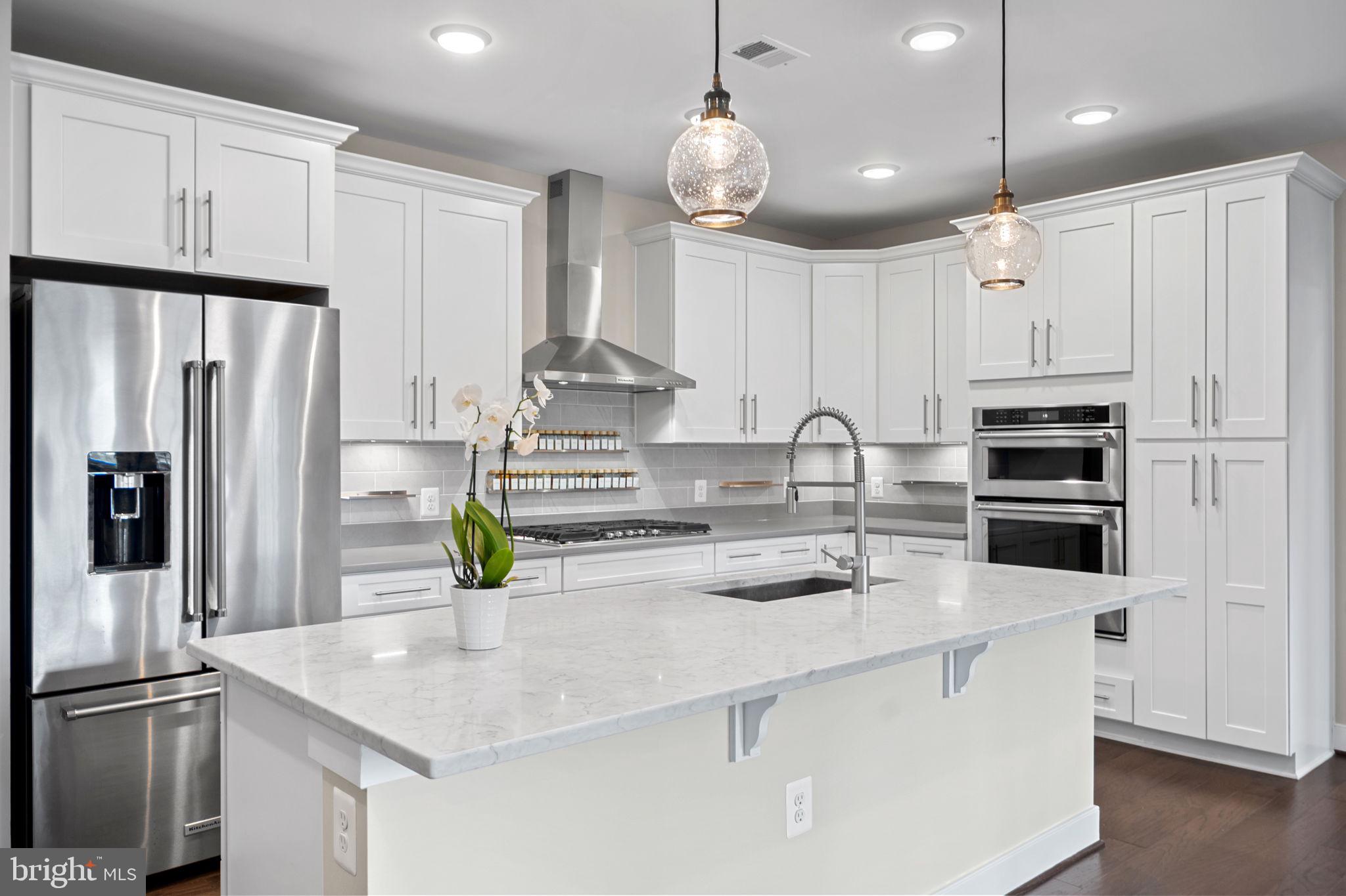 210 Decoverly Drive, Unit 106 Gaithersburg, MD 20878 - Photo 3 of 59 a kitchen with stainless steel appliances a sink a stove a microwave and cabinets