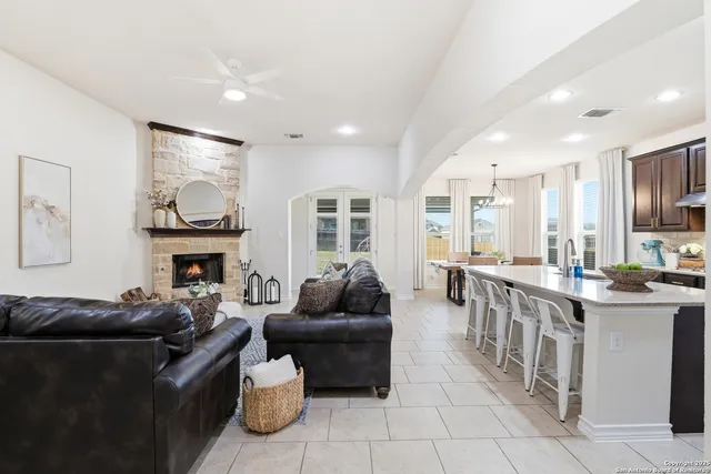 a kitchen with stainless steel appliances granite countertop a stove top oven a sink dishwasher a refrigerator and a cabinets with wooden floor