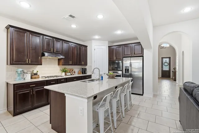 a metallic refrigerator freezer sitting in a kitchen