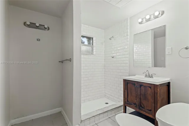 a bathroom with a sink a toilet a mirror and shower