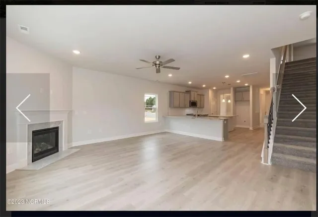 a view of a big room with windows and chandelier fan
