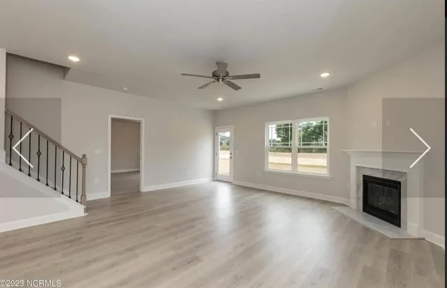 a view of an empty room and a kitchen
