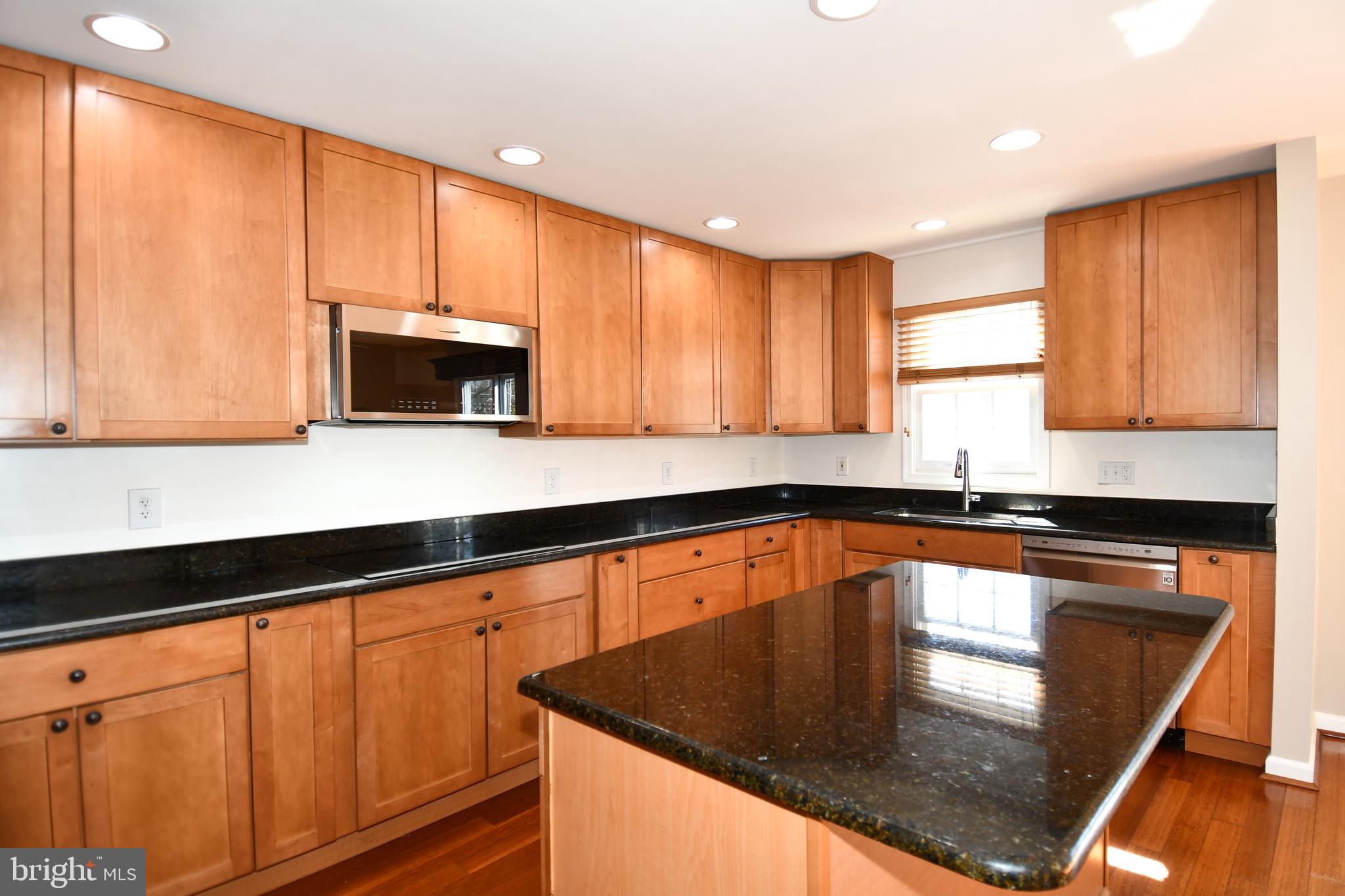 1048 Windrush Lane, Unit 39 Sandy Spring, MD 20860 - Photo 11 of 39 a kitchen with granite countertop a stove sink and microwave