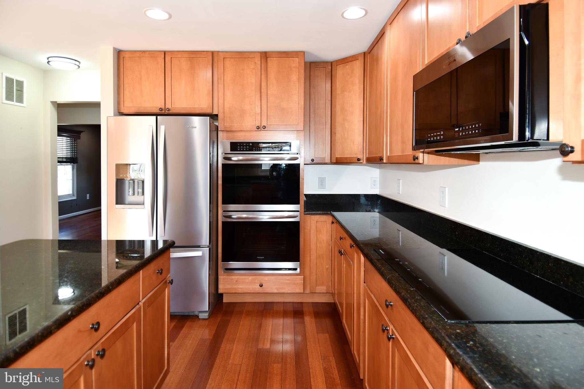 1048 Windrush Lane, Unit 39 Sandy Spring, MD 20860 - Photo 14 of 39 a kitchen with stainless steel appliances a sink dishwasher a refrigerator microwave and stove with wooden floor
