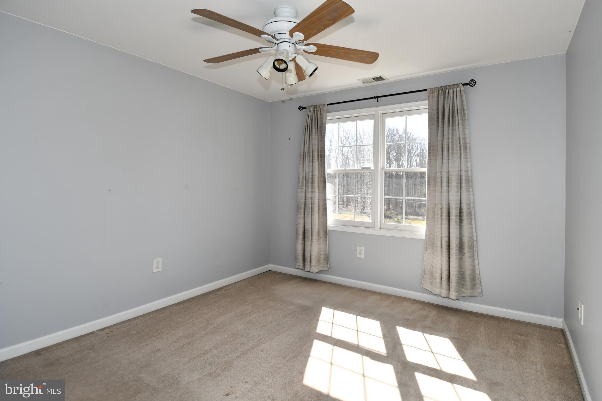 1048 Windrush Lane, Unit 39 Sandy Spring, MD 20860 - Photo 26 of 39 an empty room with windows and ceiling fan