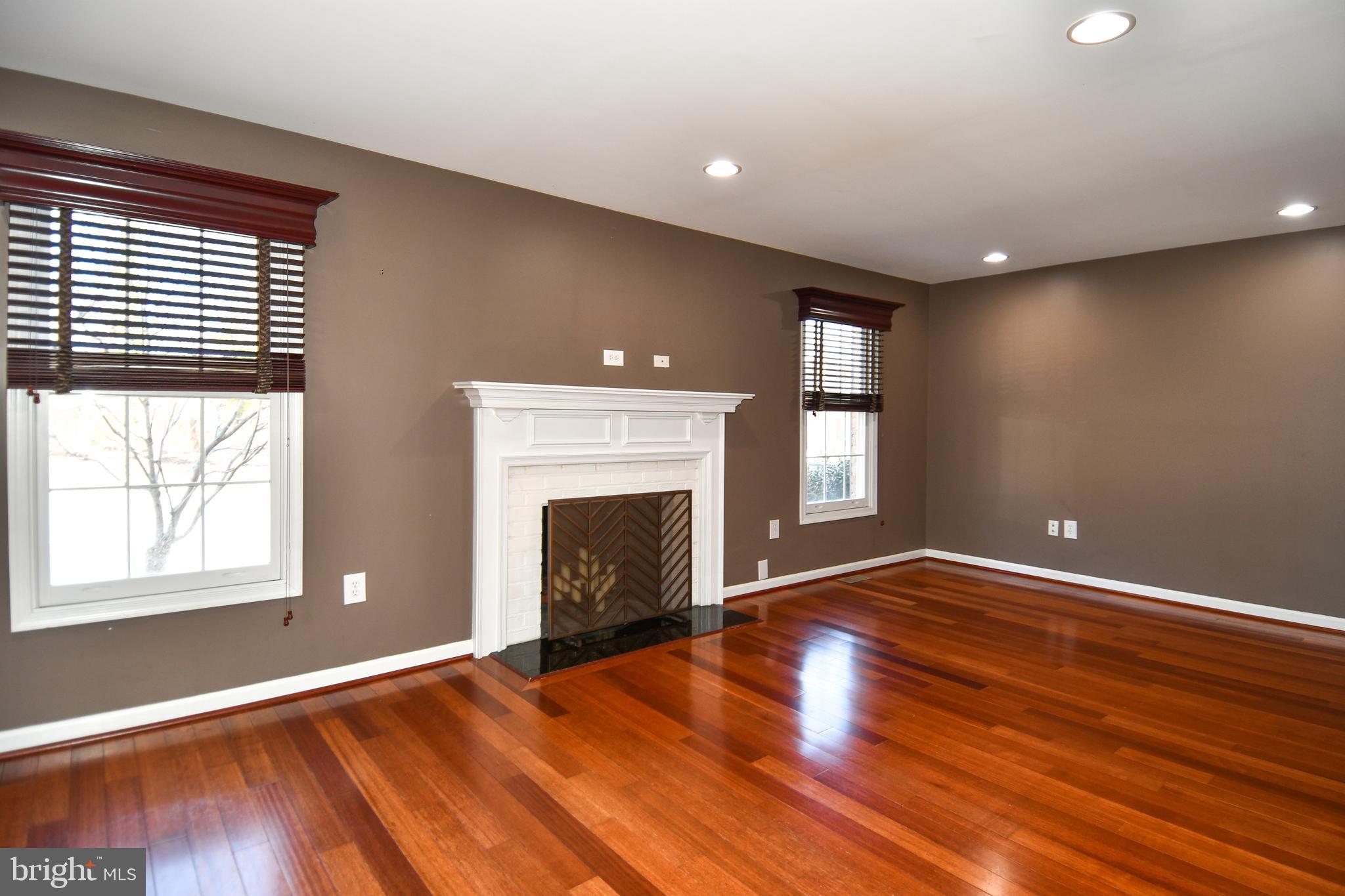 1048 Windrush Lane, Unit 39 Sandy Spring, MD 20860 - Photo 4 of 39 an empty room with wooden floor fireplace and windows