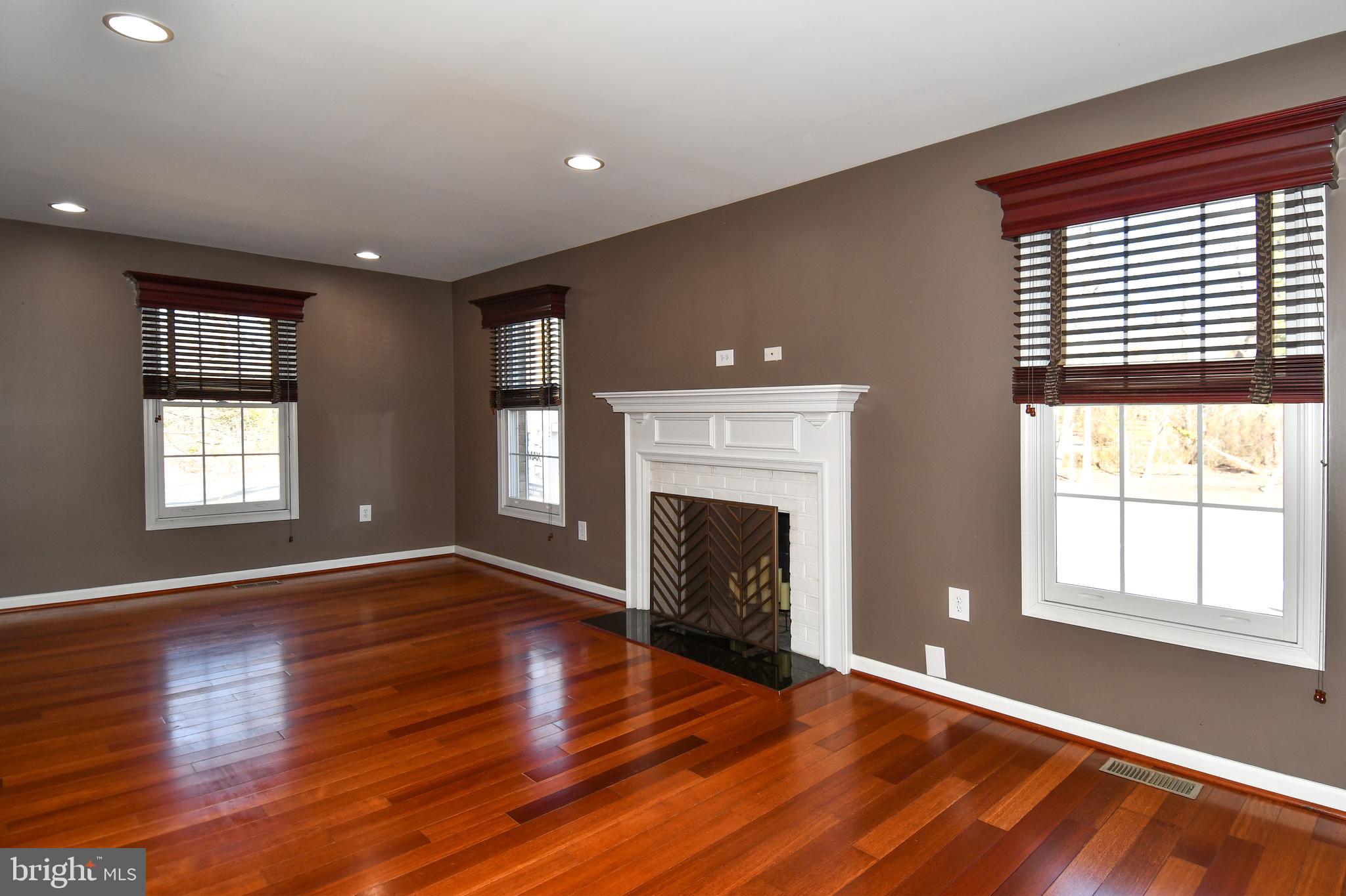 1048 Windrush Lane, Unit 39 Sandy Spring, MD 20860 - Photo 6 of 39 an empty room with wooden floor fireplace and windows