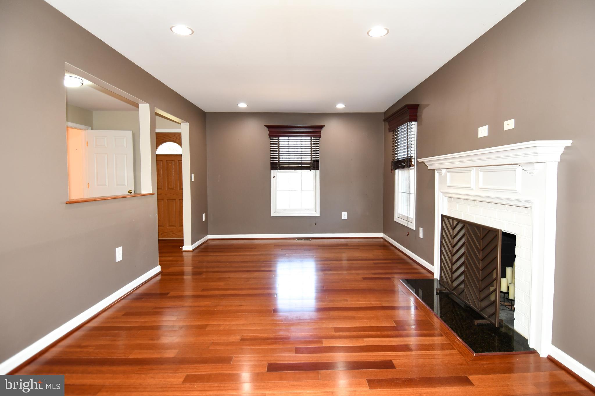 1048 Windrush Lane, Unit 39 Sandy Spring, MD 20860 - Photo 7 of 39 a view of an empty room with wooden floor fireplace and a window