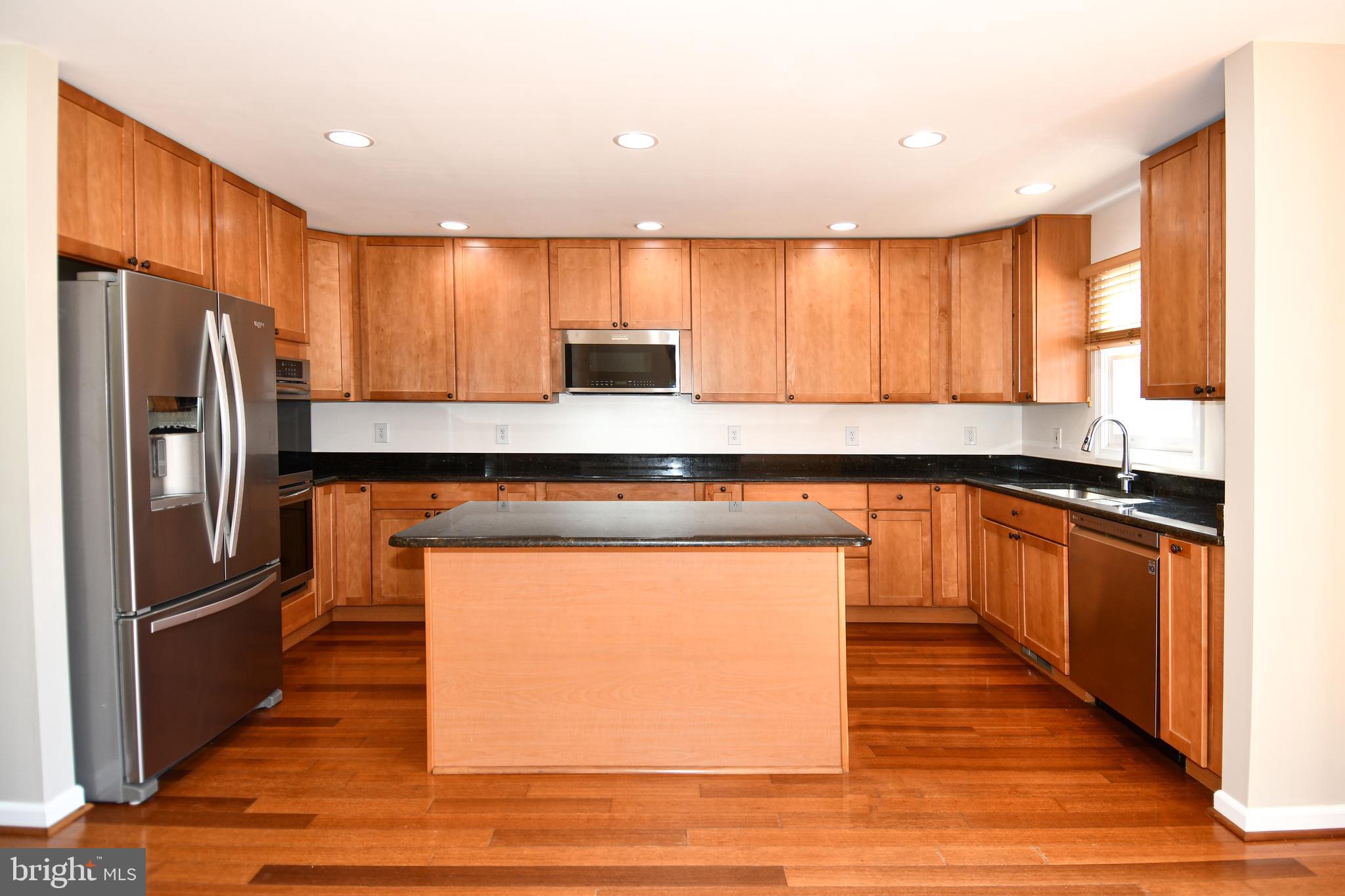 1048 Windrush Lane, Unit 39 Sandy Spring, MD 20860 - Photo 9 of 39 a kitchen with stainless steel appliances granite countertop a refrigerator a sink a stove and island