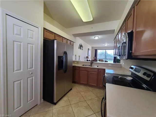 a kitchen with stainless steel appliances a stove microwave and sink