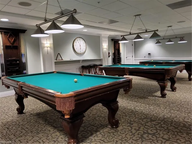 a room with pool table and a clock