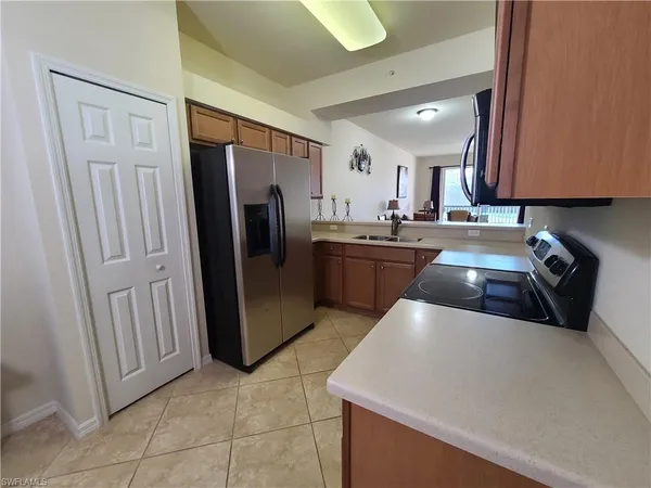 a kitchen with stainless steel appliances granite countertop a refrigerator a sink a stove and island