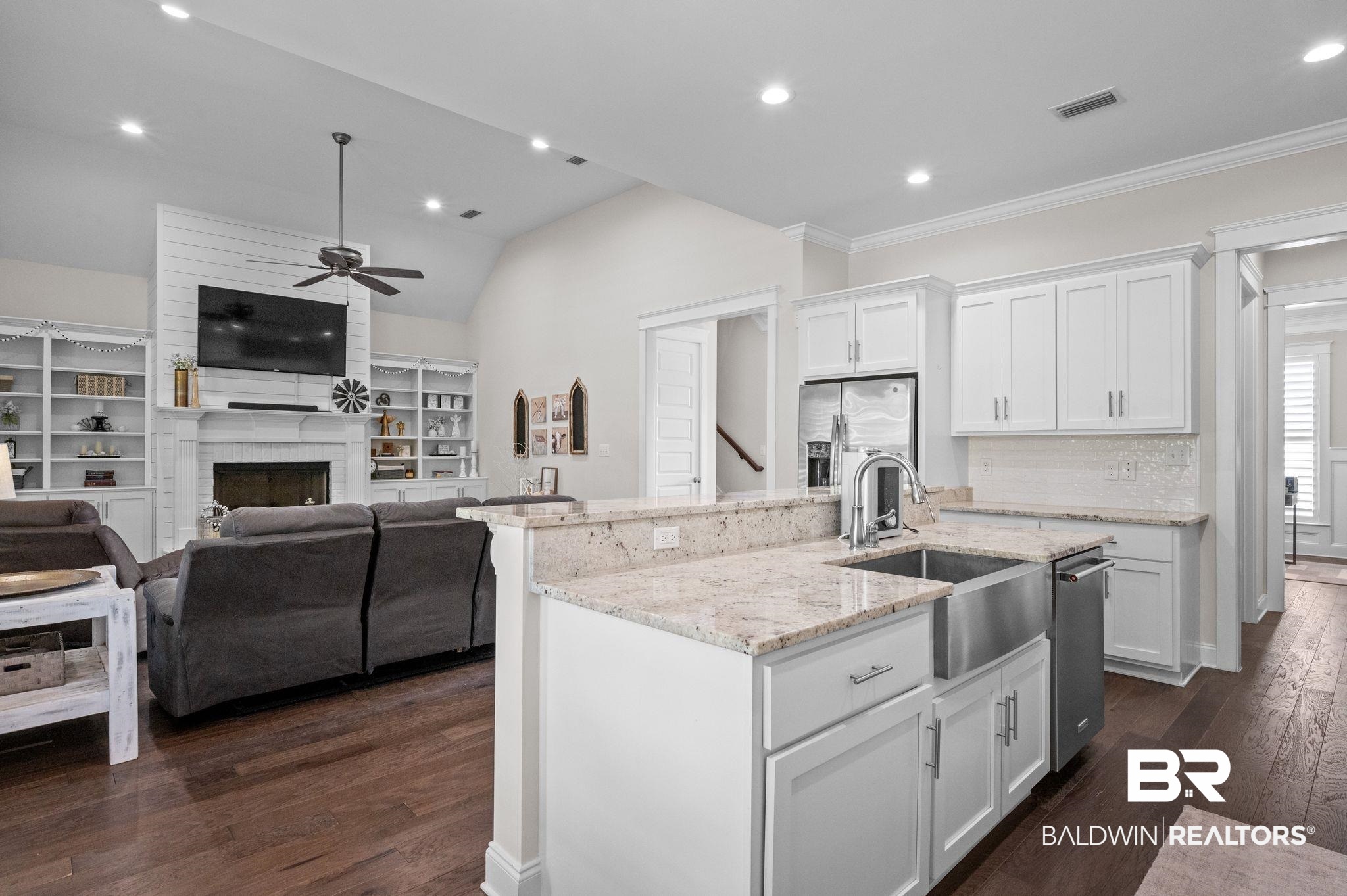 32194 Badger Court Daphne, AL 36527 - Photo 18 of 49 Kitchen with white cabinets, a fireplace, light stone counters, a kitchen island with sink, and recessed lighting
