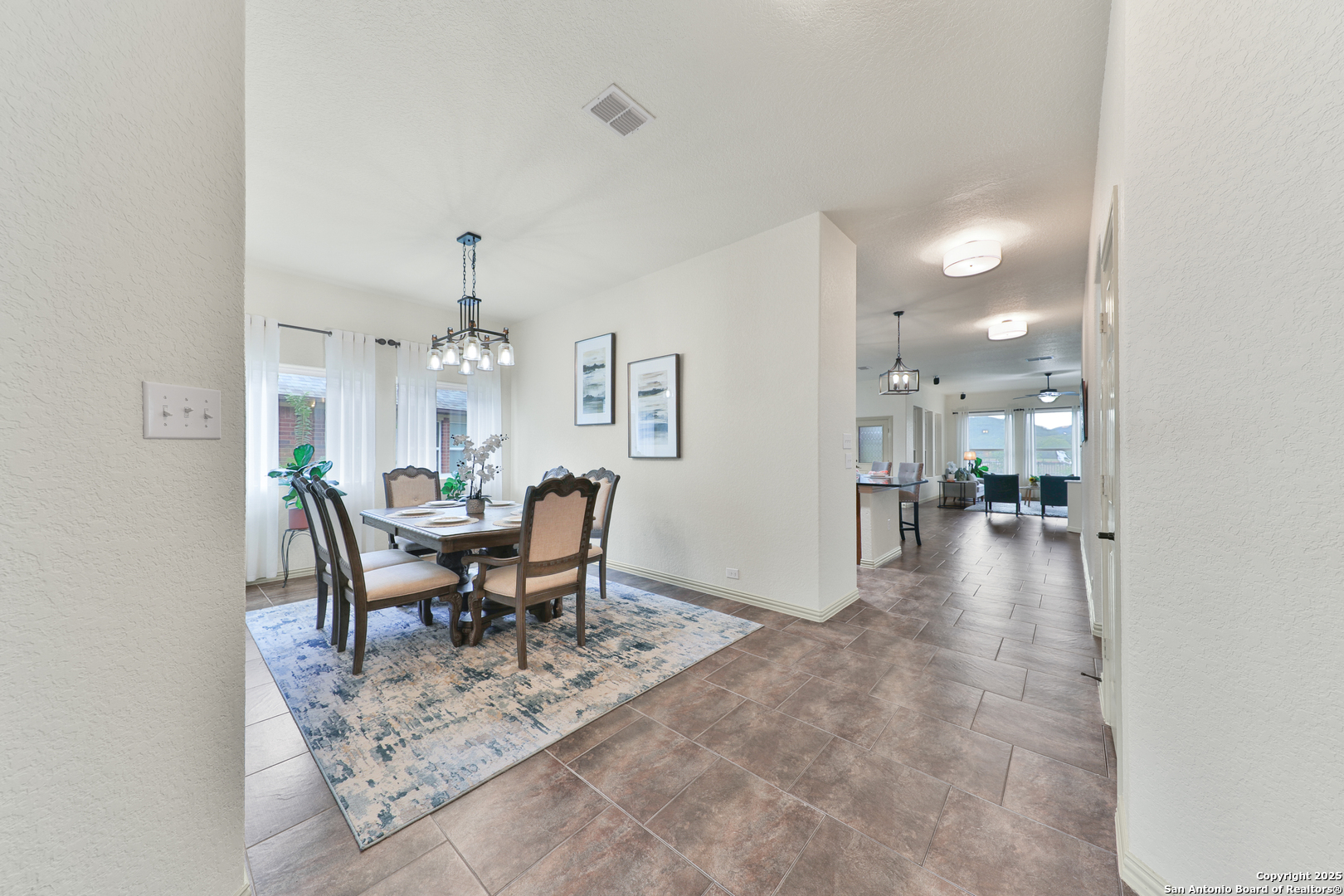 10811 Newcroft Place Helotes, TX 78023 - Photo 13 of 52 a view of a dining room with furniture and a chandelier