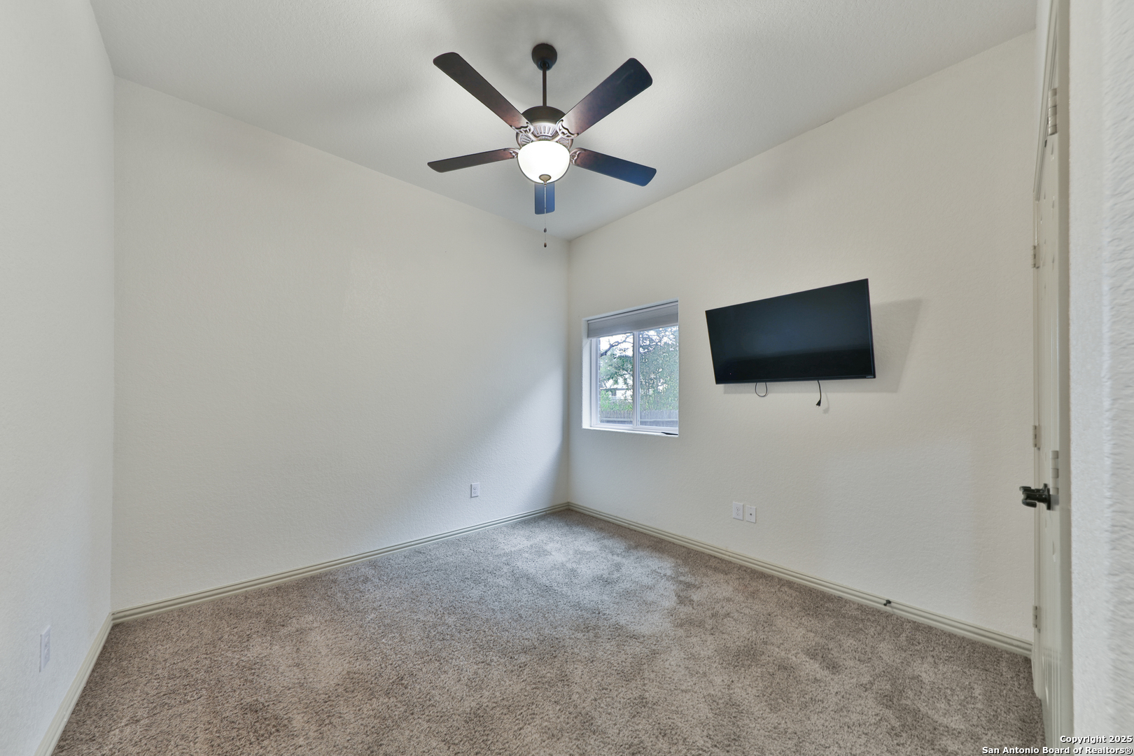 10811 Newcroft Place Helotes, TX 78023 - Photo 17 of 52 a living room with a flat screen tv and a ceiling fan