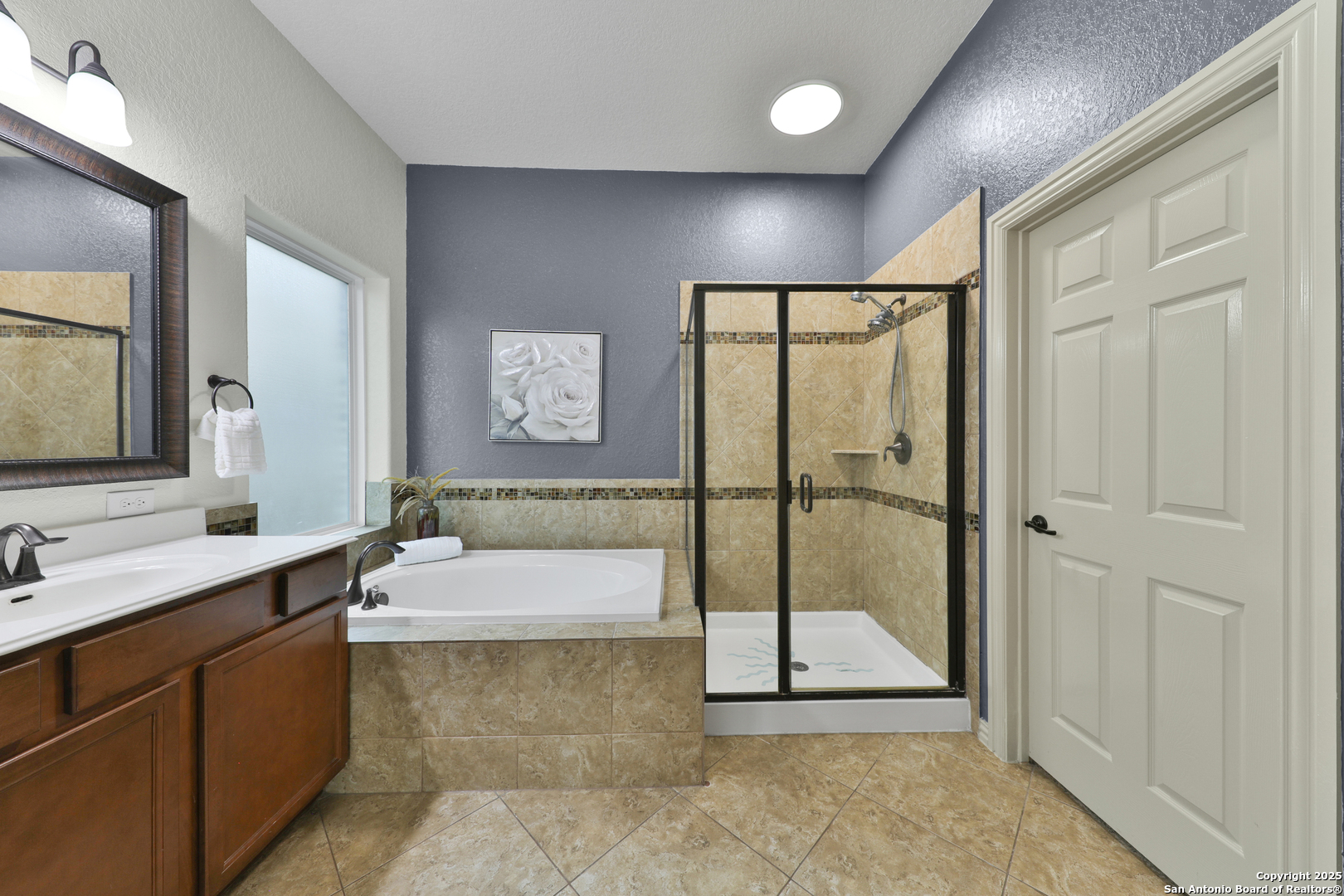 10811 Newcroft Place Helotes, TX 78023 - Photo 25 of 52 a bathroom with a tub a sink and mirror