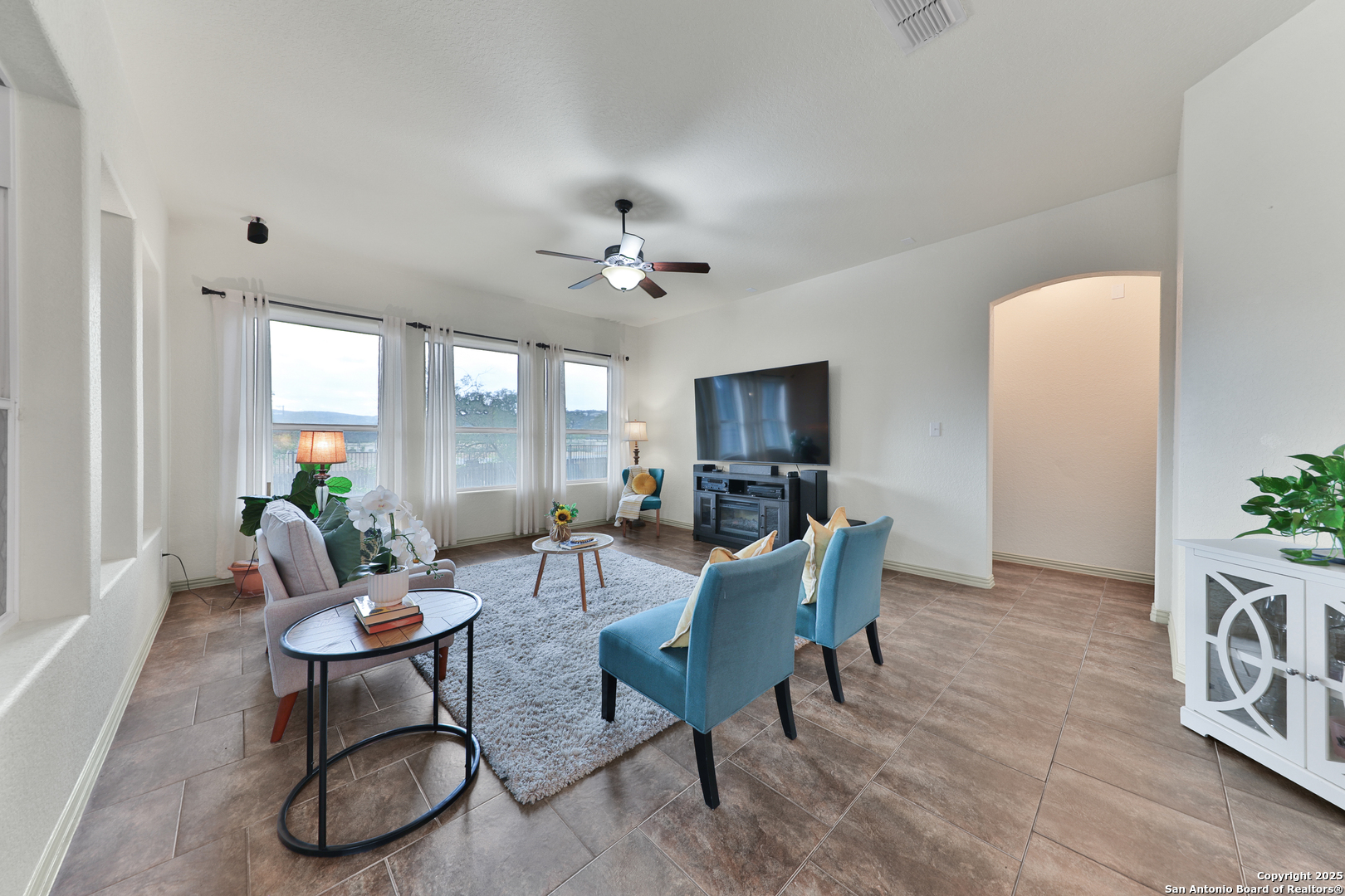 10811 Newcroft Place Helotes, TX 78023 - Photo 28 of 52 a living room with furniture a chandelier and a window