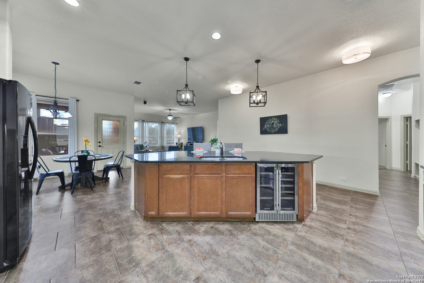 10811 Newcroft Place Helotes, TX 78023 - Photo 37 of 52 an open kitchen with granite countertop a stove a sink a oven and a dining table