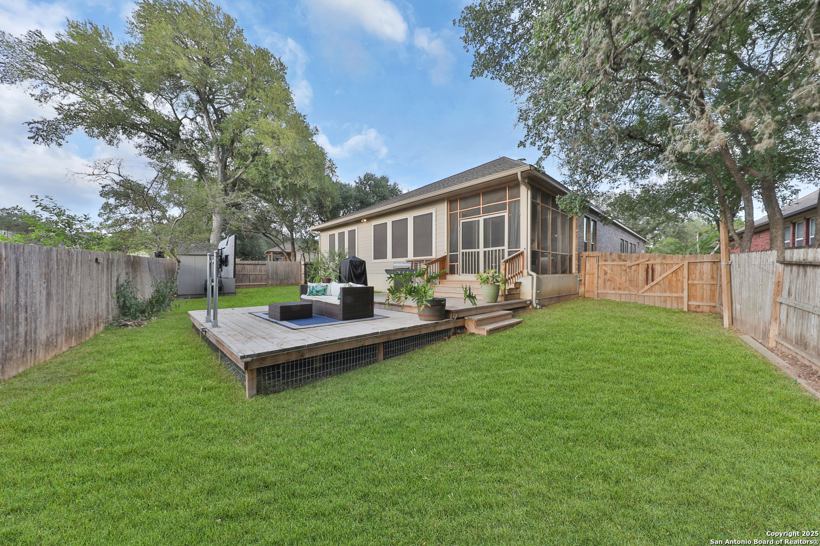 10811 Newcroft Place Helotes, TX 78023 - Photo 40 of 52 a view of a backyard with table and chairs potted plants and large tree