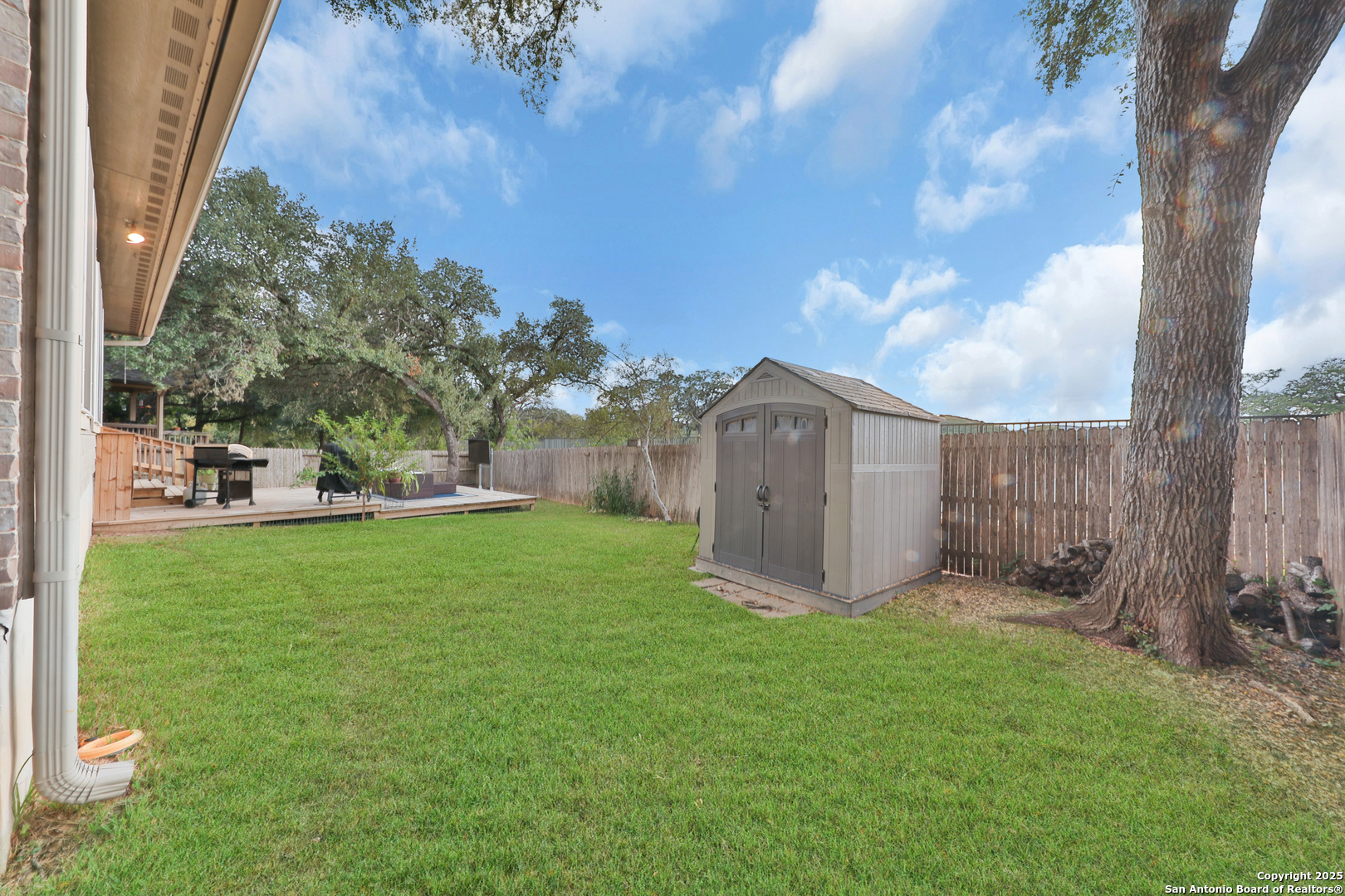 10811 Newcroft Place Helotes, TX 78023 - Photo 42 of 52 a view of a tiny house with a big yard and large trees