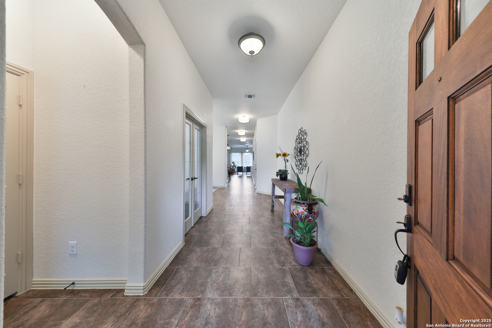 10811 Newcroft Place Helotes, TX 78023 - Photo 5 of 52 a hallway with wooden floor potted plants with wooden floor