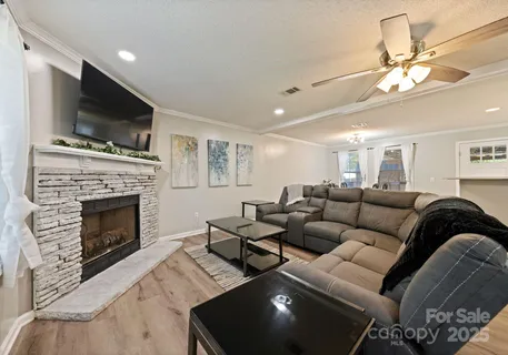 a living room with furniture a flat screen tv and a fireplace