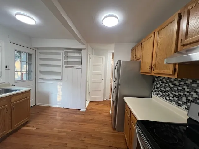 a room with a wooden floor and cabinets