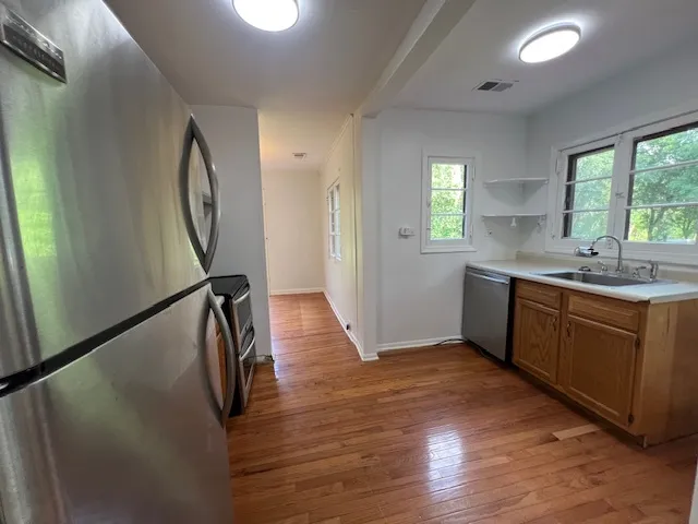 a kitchen with sink cabinets and wooden floor