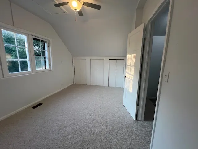 a view of empty room with a ceiling fan and window
