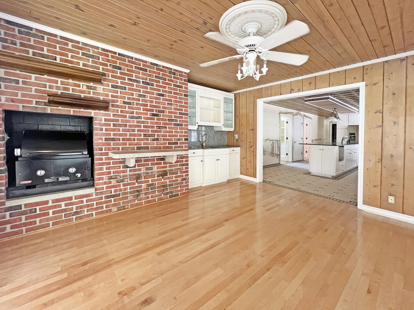 1017 Fisk Road Compton, IL 61318 - Photo 24 of 60 a view of an empty room and a kitchen with wooden floor
