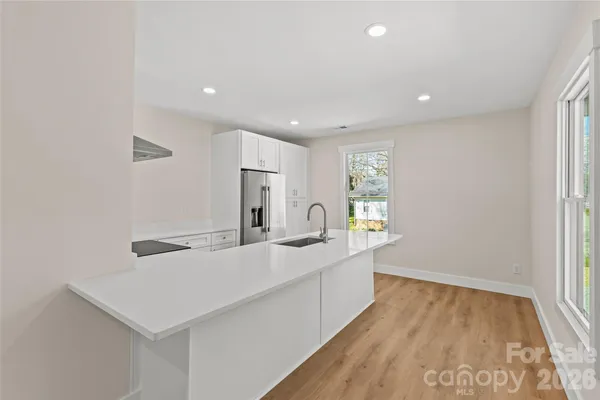 a kitchen with stainless steel appliances a sink dishwasher and a refrigerator