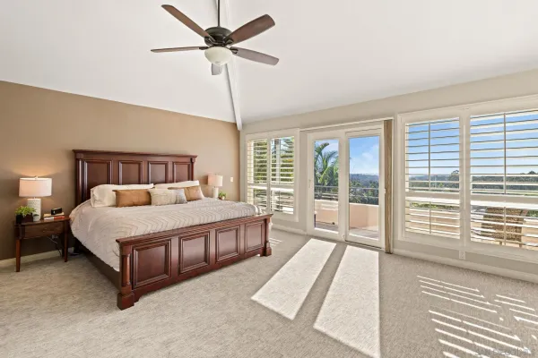 a bed sitting in a spacious bedroom next to a window