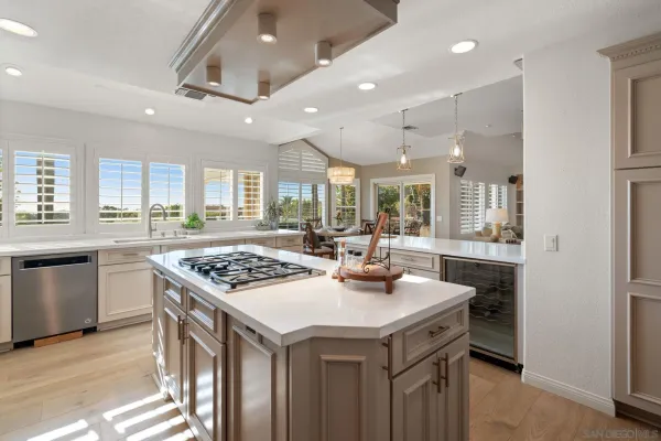 a kitchen with granite countertop a sink a stove and cabinets