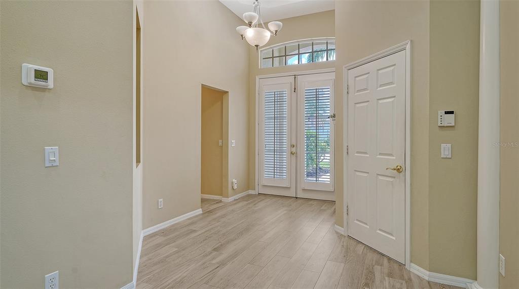 7717 US Open Loop Lakewood Ranch, FL 34202 - Photo 4 of 95 a view of a hallway with wooden floor and a livingroom