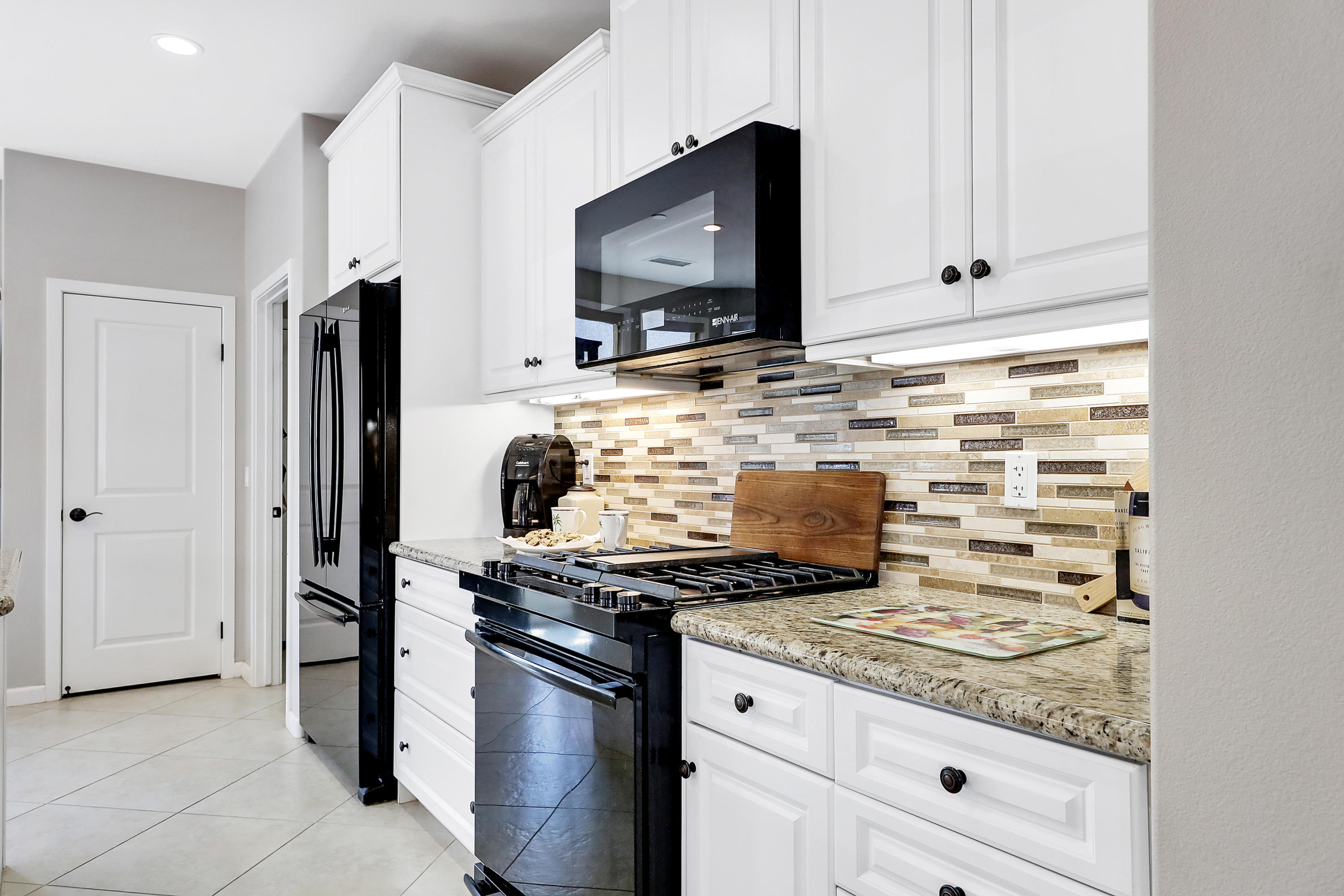 82782 Kingsboro Lane Indio, CA 92201 - Photo 15 of 39 a kitchen with stainless steel appliances granite countertop a stove microwave and refrigerator