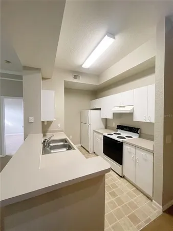 a large white kitchen with granite countertop a sink