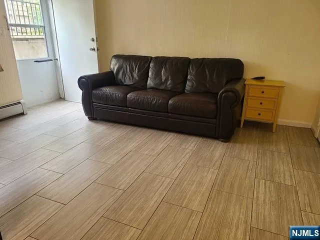a living room with a couch and a dresser with wooden floor