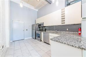 210 Walker Street Southwest, Unit 1 Atlanta, GA 30313 - Photo 17 of 37 a kitchen with granite countertop a sink and a stove