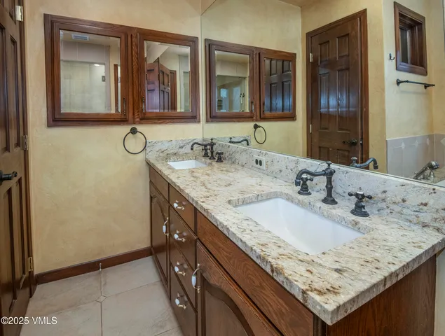 a living room with stainless steel appliances furniture a fireplace and a kitchen view