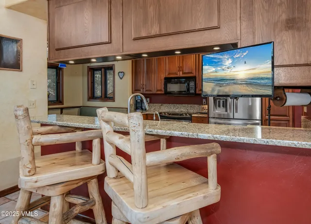 a large kitchen with stainless steel appliances granite countertop a sink and cabinets