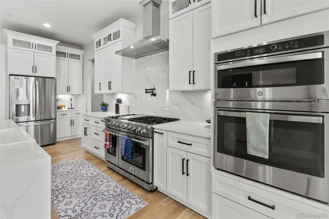 a kitchen with cabinets stainless steel appliances and wooden floor