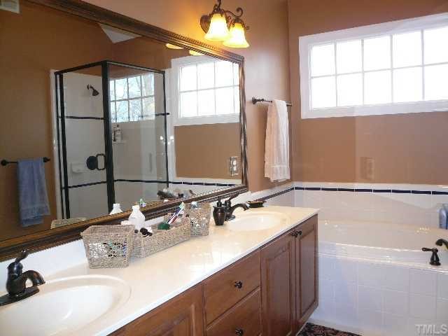 5908 Orchid Valley Road Raleigh, NC 27613 - Photo 8 of 12 a bathroom with a double vanity sink window and a bathtub