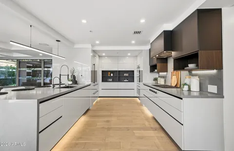 a large white kitchen with stainless steel appliances granite countertop lots of counter top space