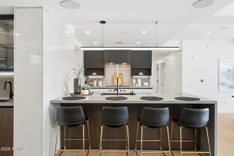 a kitchen with a sink and chairs