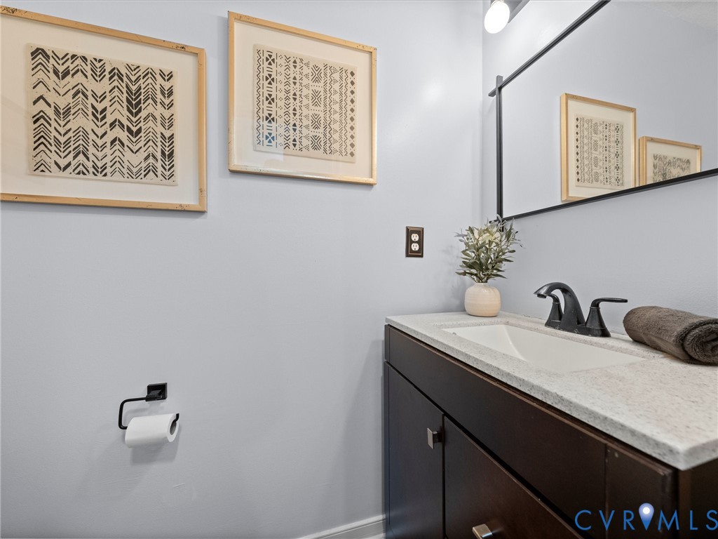 6712 Hedges Road Richmond, VA 23224 - Photo 13 of 34 Bathroom vanity featuring a dark wood-finish cabin