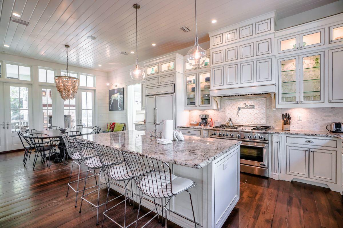 155 Bluejack Street Santa Rosa Beach, FL 32459 - Photo 3 of 28 a kitchen with stainless steel appliances granite countertop a stove top oven a sink dishwasher and white cabinets with wooden floor