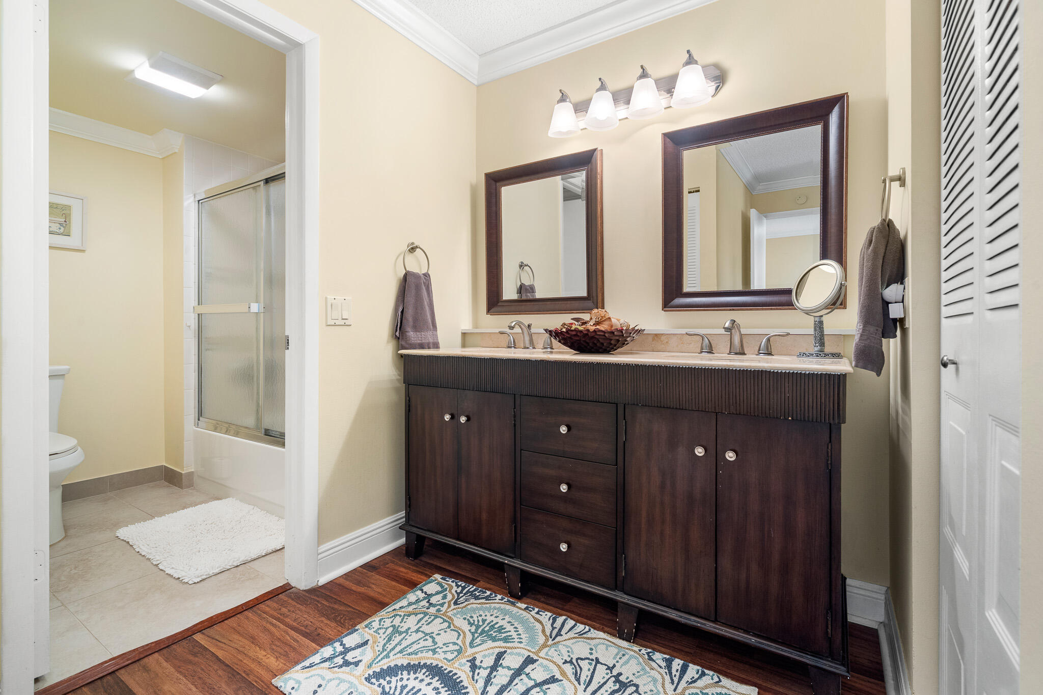 21218 Lago Circle, Unit H Boca Raton, FL 33433 - Photo 25 of 43 a bathroom with a double vanity sink and a mirror